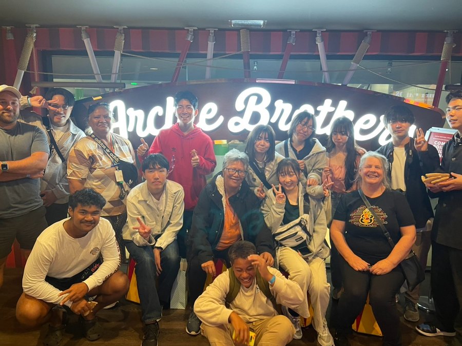 A large group of students together at an evening social outing in Auckland.